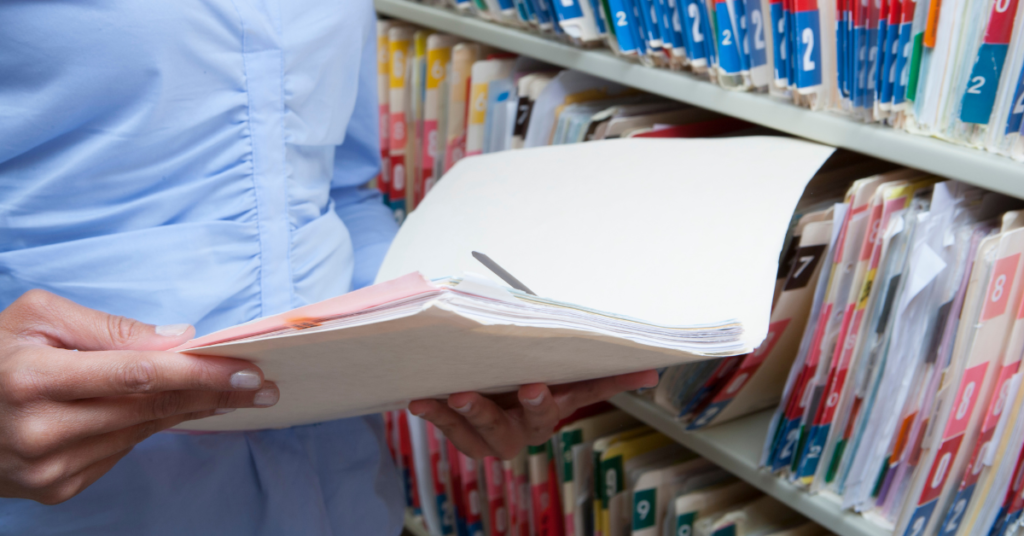medical record staff holding a record in hand